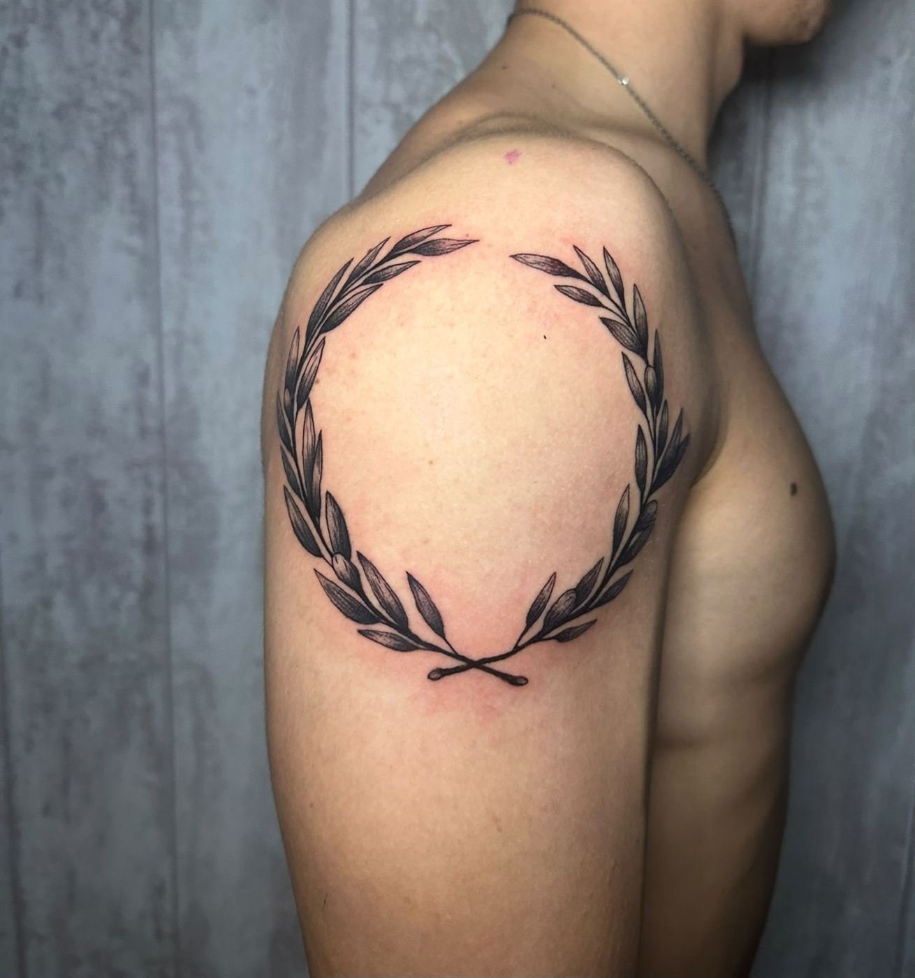 Corona de laurel tatuada en el hombro